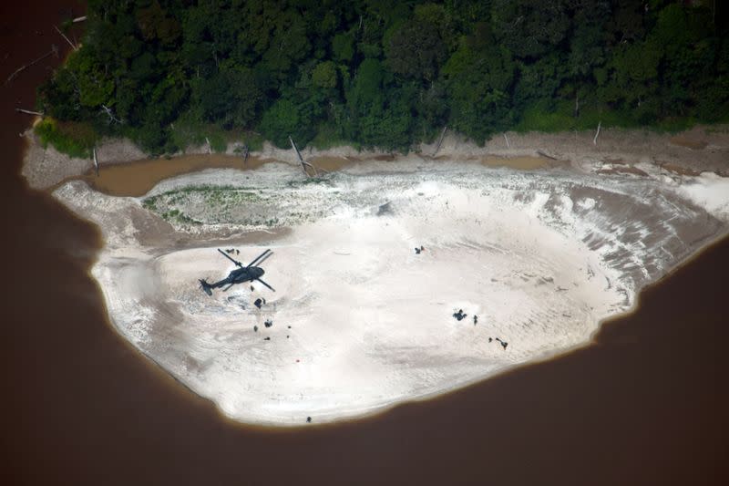 A Colombian Air Force helicopter flies over an illegal mining site for gold extraction during a joint operation between Colombian and Brazilian authorities in the Amazon jungles