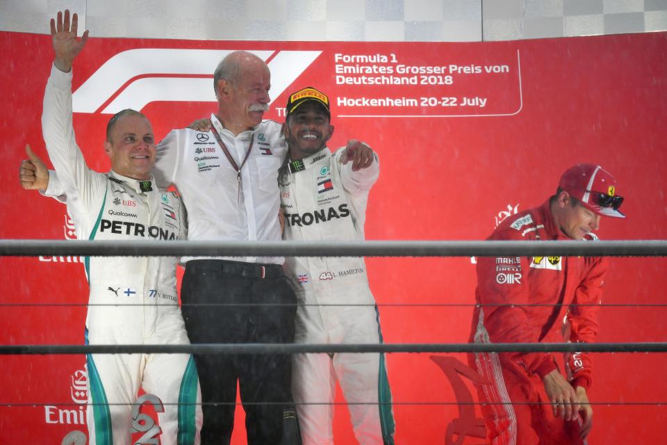 Gain in the rain: Bottas, Hamilton and Daimler CEO Deiter Zetsche on the podium with third-place Raikkonen
