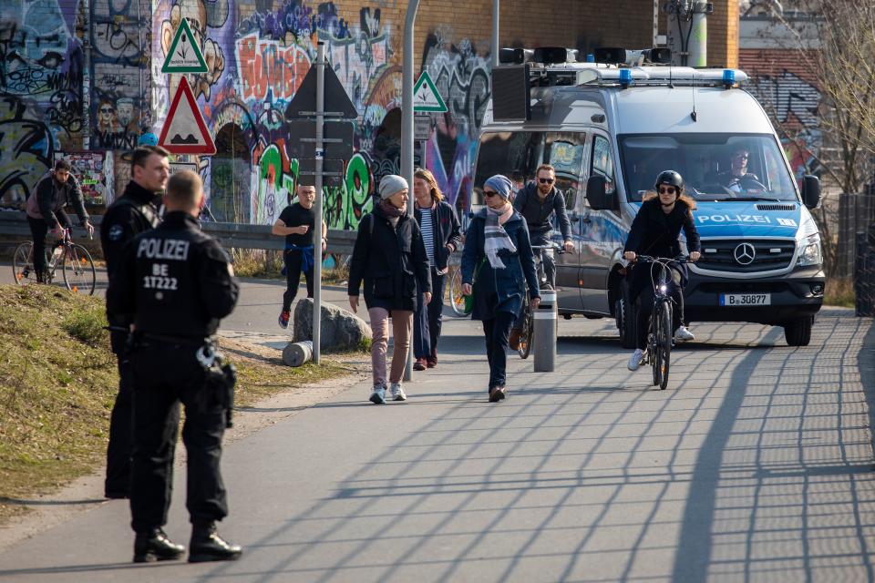 Patrolling police officers use a tannoy and screens mounted on a police van to address people gathering in Gleisdreieck park Berlin on March 28, 2020 amid the novel coronavirus pandemic. - Police patrolled parks and public spaces on Saturday as people was adviced to implement social distancing and not mingle in units more than two people at the time, but as the tempratue rose to high teens celsius in the German capital more people head out to greet the spring despite government advice to the opposite. (Photo by Odd ANDERSEN / AFP) (Photo by ODD ANDERSEN/AFP via Getty Images)