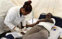 A man donates blood at a temporary donation centre for the injured victims of a crossfire between armed men and the police at the Westgate shopping mall, in Kenya's capital Nairobi September 22, 2013. Islamist militants were holed up with hostages on Sunday at a shopping mall in Nairobi, where at least 59 people have been killed in an attack by the al Shabaab group that opposes Kenya's participation in a peacekeeping mission in neighboring Somalia. REUTERS/Thomas Mukoya (KENYA - Tags: CIVIL UNREST CRIME LAW)