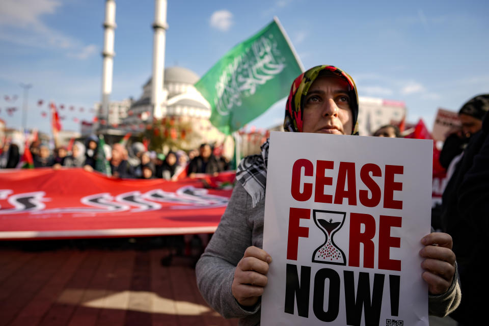 A woman holds a placard as she marches with others during a protest in support of Palestinians and calling for an immediate ceasefire in Gaza, in Istanbul, Turkey, Sunday, Jan. 14, 2024. (AP Photo/Emrah Gurel)