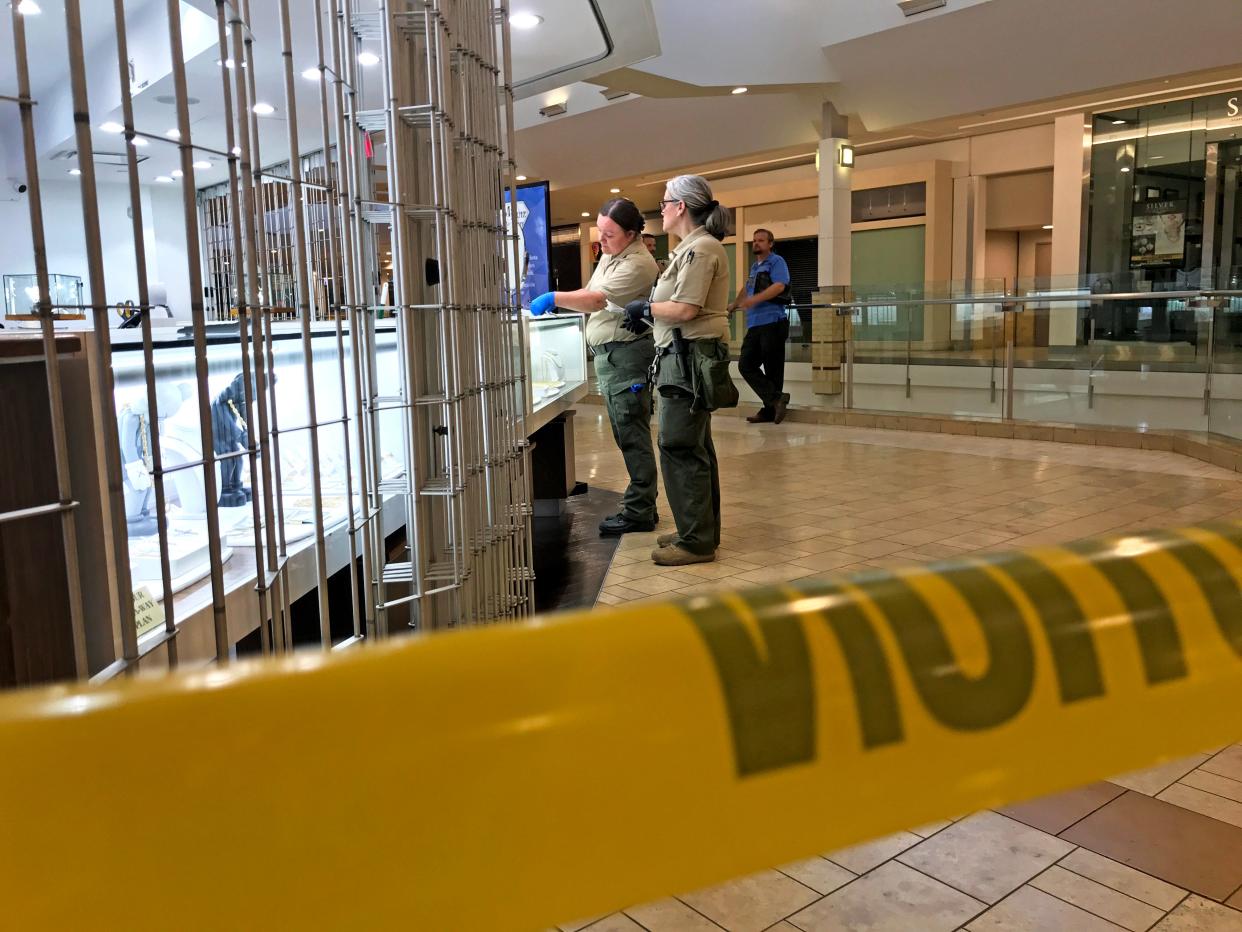 The Riverside County sheriff’s forensic team investigates a robbery at M. Ruiz Jewelers inside the Palm Desert mall Tuesday evening.