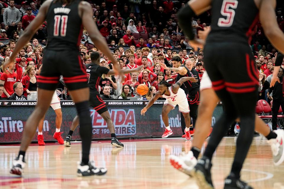 Ohio State guard Bruce Thornton passes the ball to teammate Tanner Holden, red shoes at left, in the final seconds against Rutgers. Holden hit a 3-pointer to win the game.