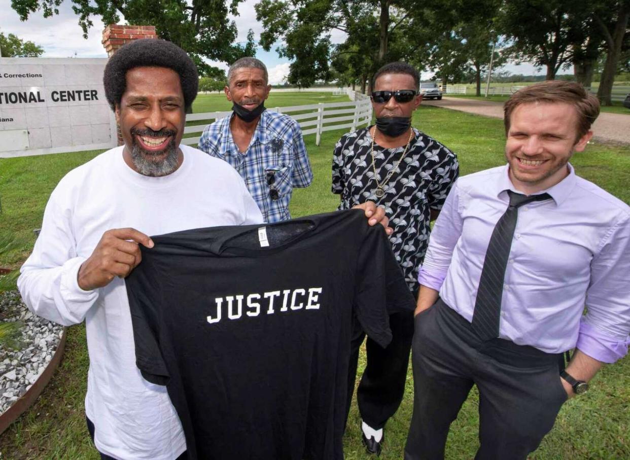 Sullivan Walter, 53, left, holds a shirt near Elayn Hunt Correctional Center in St. Gabriel, La., with, left to right, his brothers Corner Walter, Jr. and Byron Walter, Sr., and Innocence Project New Orleans legal director Richard Davis, just after his release on Thursday, Aug. 25, 2022. (Travis Spradling/The Advocate via AP)