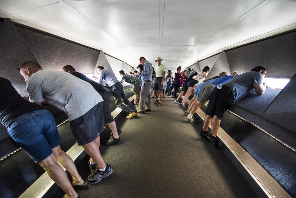 Tourists look out the windows at the top of the Gateway Arch.