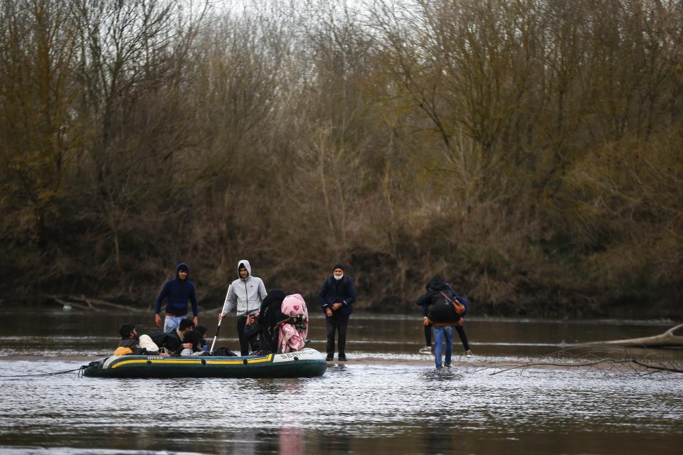 Migrants prepare to enter Greece from Turkey by crossing the Maritsa river in an inflatable boat, Saturday, Feb. 29, 2020. Turkish President Recep Tayyip Erdogan said Saturday that his country's borders with Europe were open, as thousands of refugees gathered at the frontier with Greece. (AP Photo/Emrah Gurel)