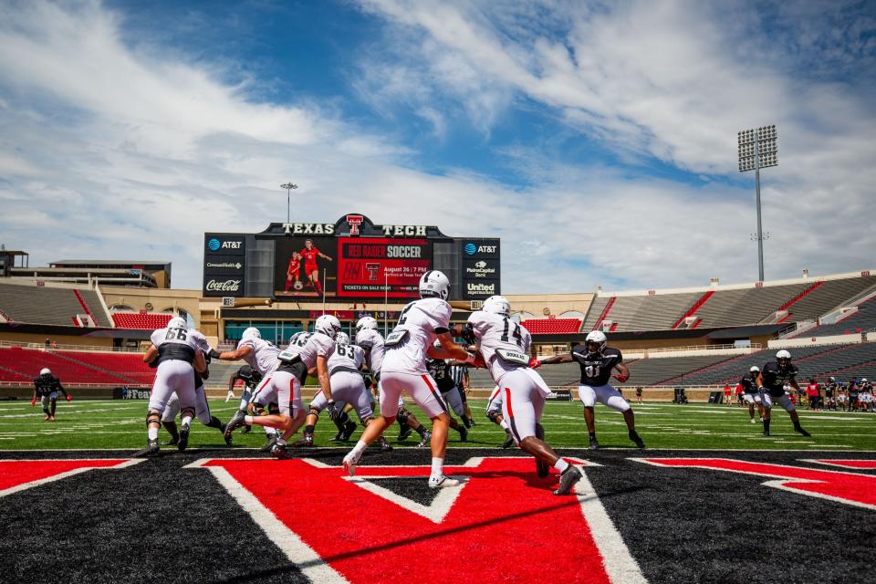 Texas Tech quarterback Behren Morton (2) hands the ball to running back Xavier White (14) during the scrimmage on Saturday, Aug. 21, 2021, at Jones AT&T Stadium in Lubbock, Texas.