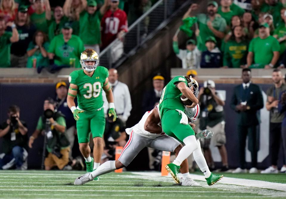 Sep 23, 2023; South Bend, Indiana, USA; Ohio State Buckeyes linebacker Cody Simon (30) stops Notre Dame Fighting Irish quarterback Sam Hartman (10) on a fourth down run during the first quarter of their game at Notre Dame Stadium.