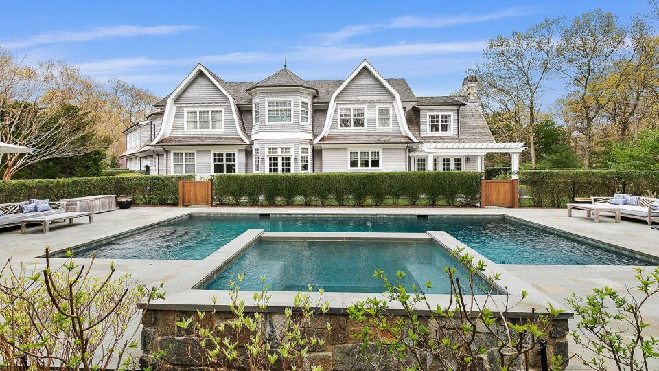 a large white house with a pool in front of it