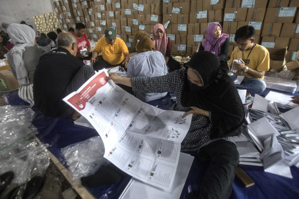 FILE - Workers fold parliamentary ballots prepared for the upcoming election at a warehouse in Medan, North Sumatra, Indonesia, Monday, Jan. 8, 2024. The world's third-largest democracy is gearing up to hold its legislative and presidential elections on Feb. 14, 2024. (AP Photo/Binsar Bakkara, File)