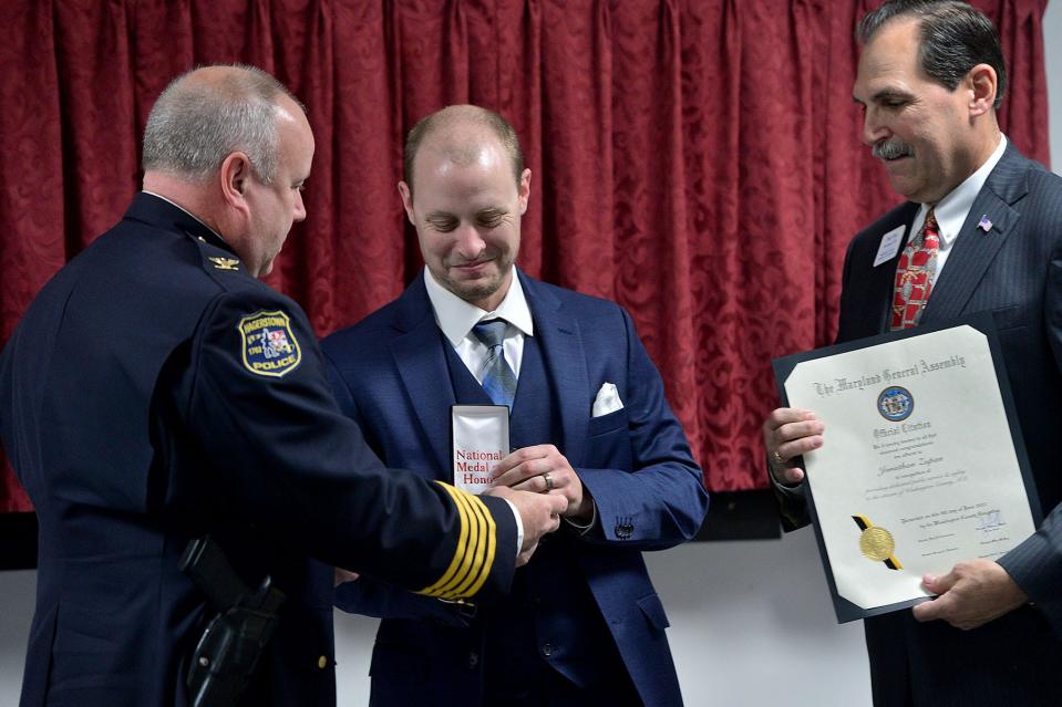 Hagerstown Police Department officer Jonathan Zupan is awarded the gold medal of valor by Hagerstown Police Chief Paul Kifer and Paul Frey, president and CEO of the Washington County Chamber of Commerce, during the Washington County Public Safety Awards Thursday held at the Community Volunteer Fire Company of District 12 in Fairplay. 