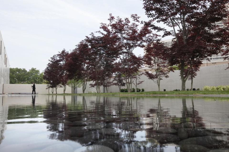 A visitor walks past a reflecting pond during a preview of The Barnes Foundation Wednesday, May 16, 2012, in Philadelphia. After years of bitter court fights, the Barnes Foundation is scheduled to open its doors to the public on May 19 at its new location on Philadelphia's "museum mile." (AP Photo/Matt Rourke)