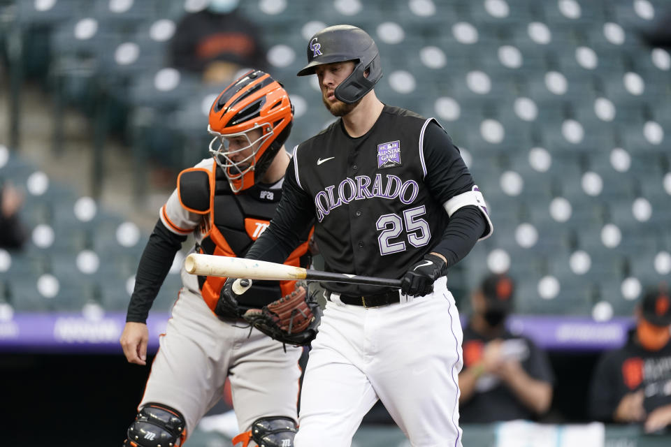 Colorado Rockies' C.J. Cron, front, reacts after striking out as San Francisco Giants catcher Buster Posey looks on in the seventh inning of game one of a baseball doubleheader Tuesday, May 4, 2021, in Denver. (AP Photo/David Zalubowski)
