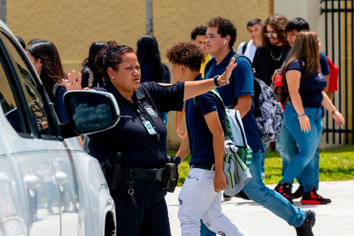 City of Miami police officer C. Gonzalez assists students leaving Miami Senior High cross the street at the end of the first day of school in Miami, Florida, on Wednesday, Aug. 17, 2022.