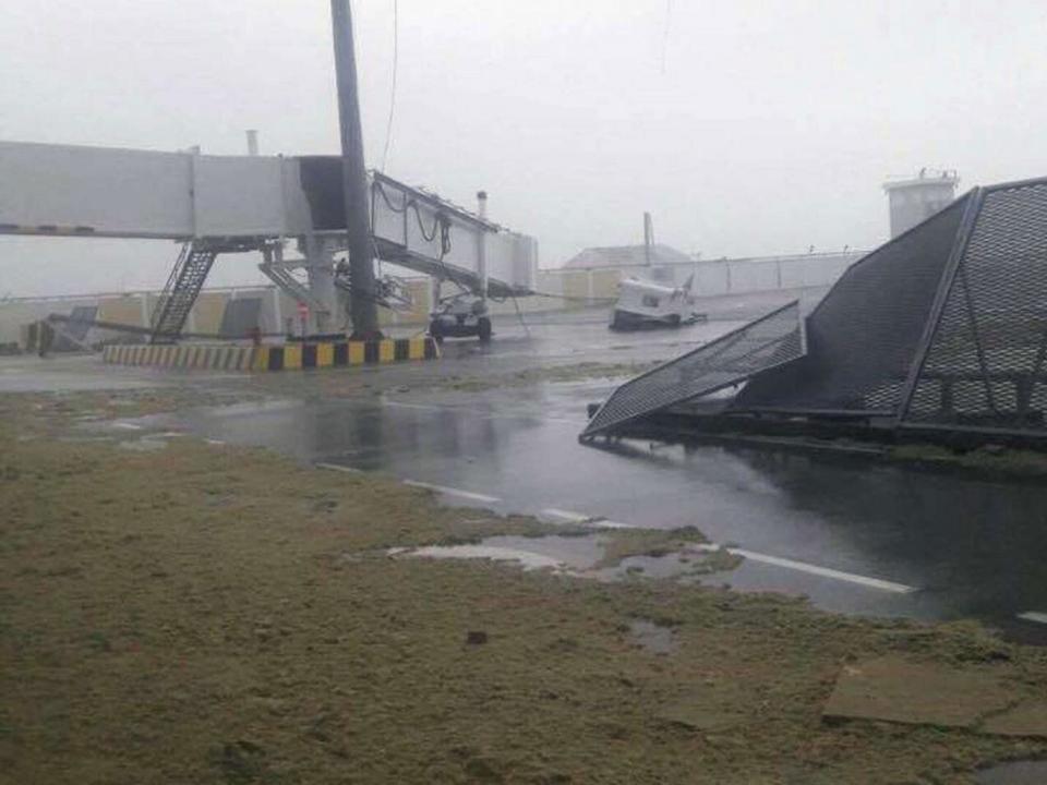 One of the airport's jet bridges was collapsed and its safety fences were pulled down, as its runway was left strewn with sand and debris (Rex Features)