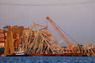 Cranes stand by as the wreckage of the Francis Scott Key Bridge rests on the container ship Dali, Saturday, March 30, 2024, in Baltimore. (AP Photo/Julia Nikhinson)