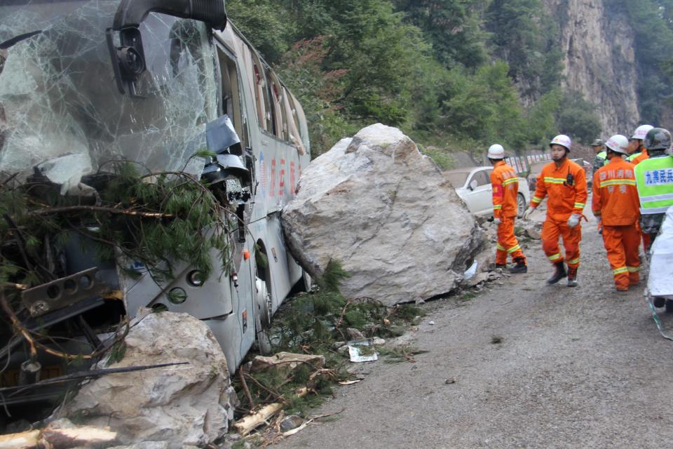 <p>Chinese paramilitary police are seen beside a wrecked tour bus as they conduct rescue operations in Jiuzhaigou in China’s southwestern Sichuan province on Aug. 9, 2017, after an 6.5-magnitude earthquake struck the province late on Aug. 8. (Photo: STR/AFP/Getty Images) </p>