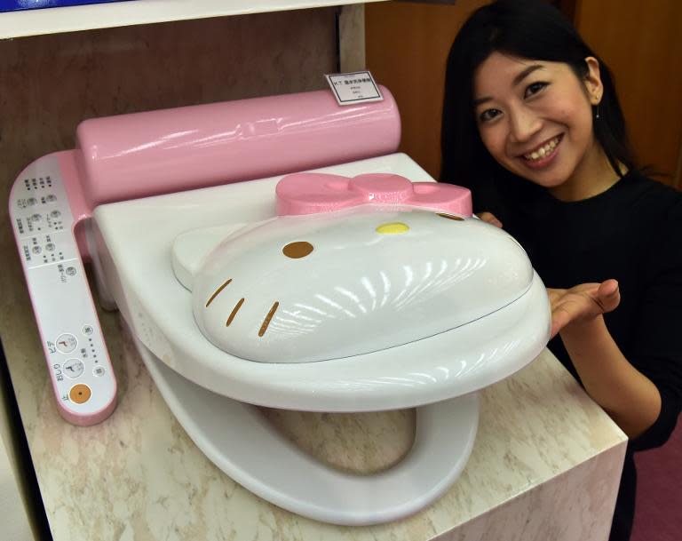 An employee for Japanese character goods maker Sanrio shows off a prototype of a Hello Kitty branded toilet seat at the company's Tokyo headquarters