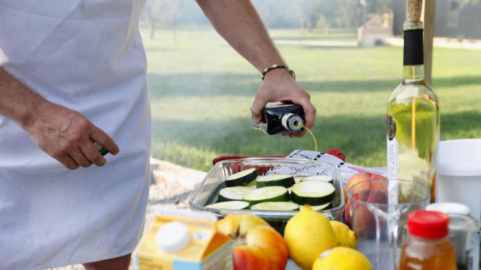 Tony Miller pours oil on slices of cucumbers on Tuesday, July 25, 2023 at Bourbon Barrel Cottages in Lawrenceburg, Ky.