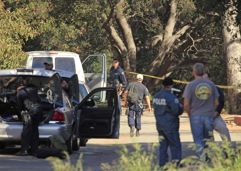 FILE - In this Jan. 18, 2012 file photo, Los Angeles Police detectives work a crime scene where a severed human head was discovered off a trail in Griffith Park in Los Angeles. Los Angeles police said Monday, March 10, 2014, they've solved the case of the severed head and other body parts found two years ago near the Hollywood sign. They announced the arrest of Gabriel Campos Martinez, 38, for the 2012 murder of Hervey Coronado Medellin, 66, of Los Angeles. Martinez was arrested in San Antonio, Texas, on Sunday with the help of local authorities and is being held without bail while he awaits extradition proceedings. (AP Photo/Al Seib, Pool, File)