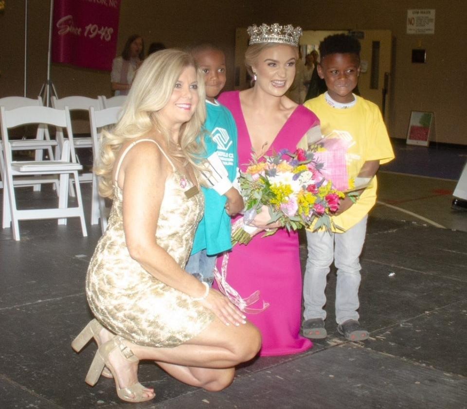Azalea Queen Carli Batson poses with Denise Szaloky, Azalea Festival president, alongside kids from Brigade Boys and Girls Club on Wednesday during the queen's coronation.