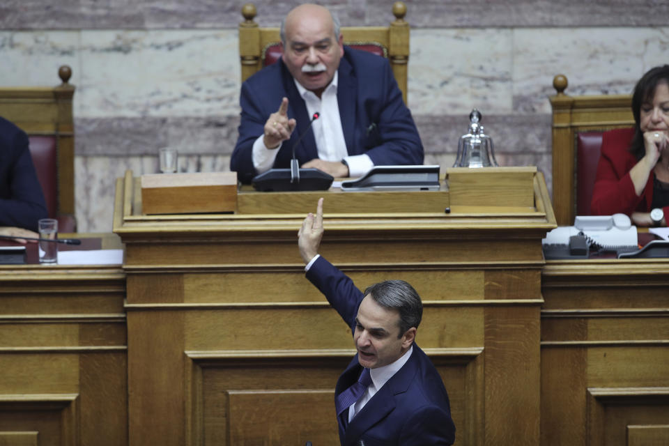 New Democracy party leader Kyriakos Mitsotakis, front, argues with Greek Parliament Speaker Nikos Voutsis during a parliament session in Athens on Tuesday, Dec. 18, 2018. Greek lawmakers are debating the heavily-indebted country's draft budget for 2019, the first since Greece exited an eight-year bailout program.(AP Photo/Petros Giannakouris)