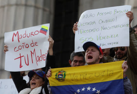 Venezuelan citizens living in Argentina shout slogans during a protest against the presidential election in Venezuela, in Buenos Aires, Argentina May 20, 2018. The banner on the right reads "Maduro trash, dictator, drug dealer" REUTERS/Martin Acosta