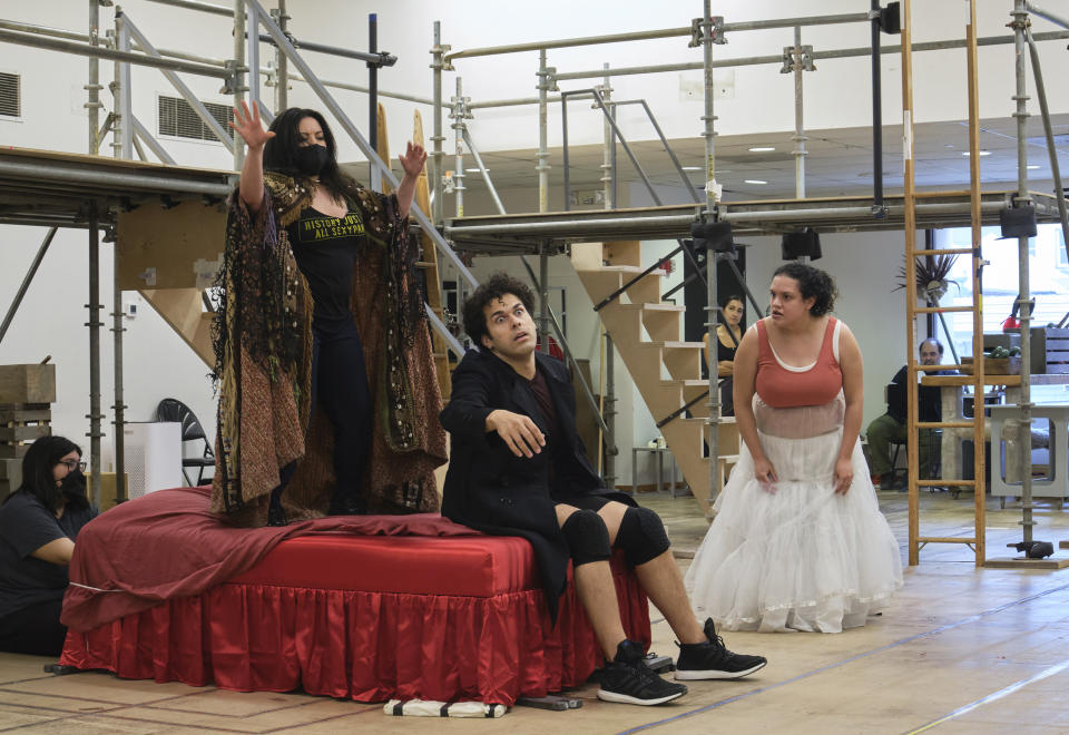 Actors Maria Christina-Oliveras, standing from left, Joel Perez and Desireé Rodriguez rehearse a scene from the musical comedy “Kiss My Aztec!” in Hartford, Conn., on May 12, 2022. The show, co-written by John Leguizamo and director Tony Taccone, will play at the Hartford Stage from June 1 to June 26. (Alan Arias via AP)