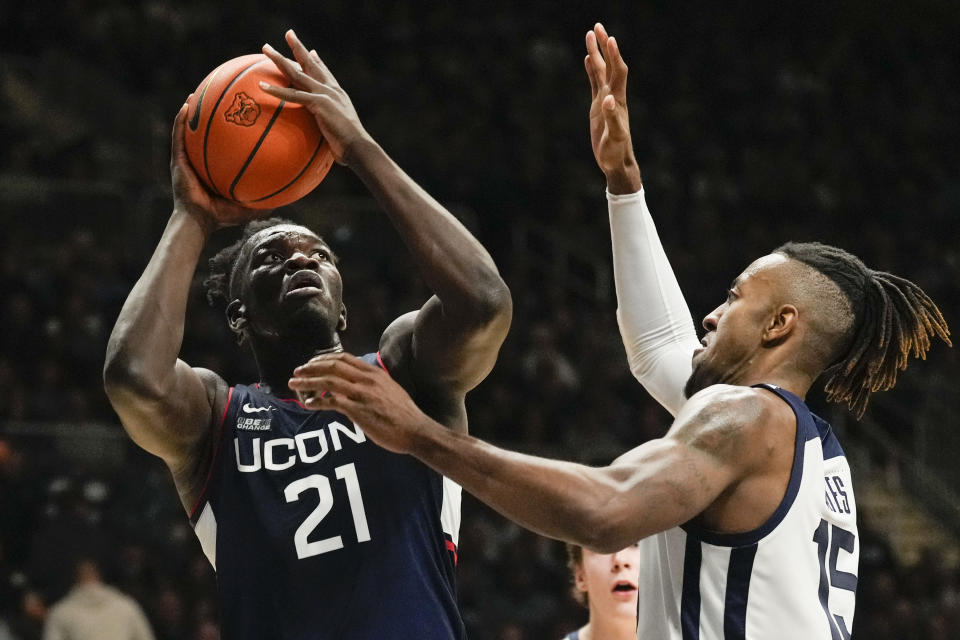 Connecticut forward Adama Sanogo (21) shoots over Butler center Manny Bates (15) in the second half of an NCAA college basketball game in Indianapolis, Saturday, Dec. 17, 2022. (AP Photo/AJ Mast)