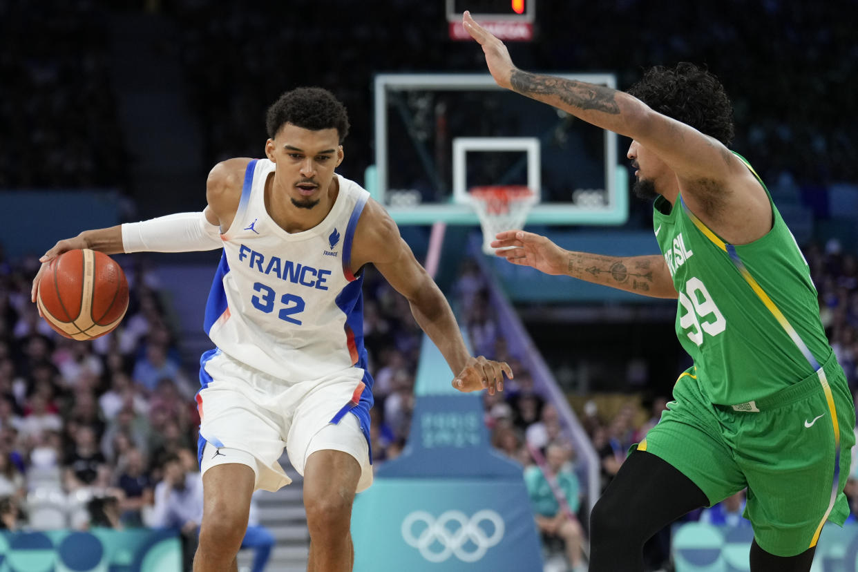 Victor Wembanyama, of France, drives on Lucas Dias, of Brazil, in a men's basketball game at the 2024 Summer Olympics, Saturday, July 27, 2024 in Villeneuve-d'Ascq, France. (AP Photo/Mark J. Terrill)