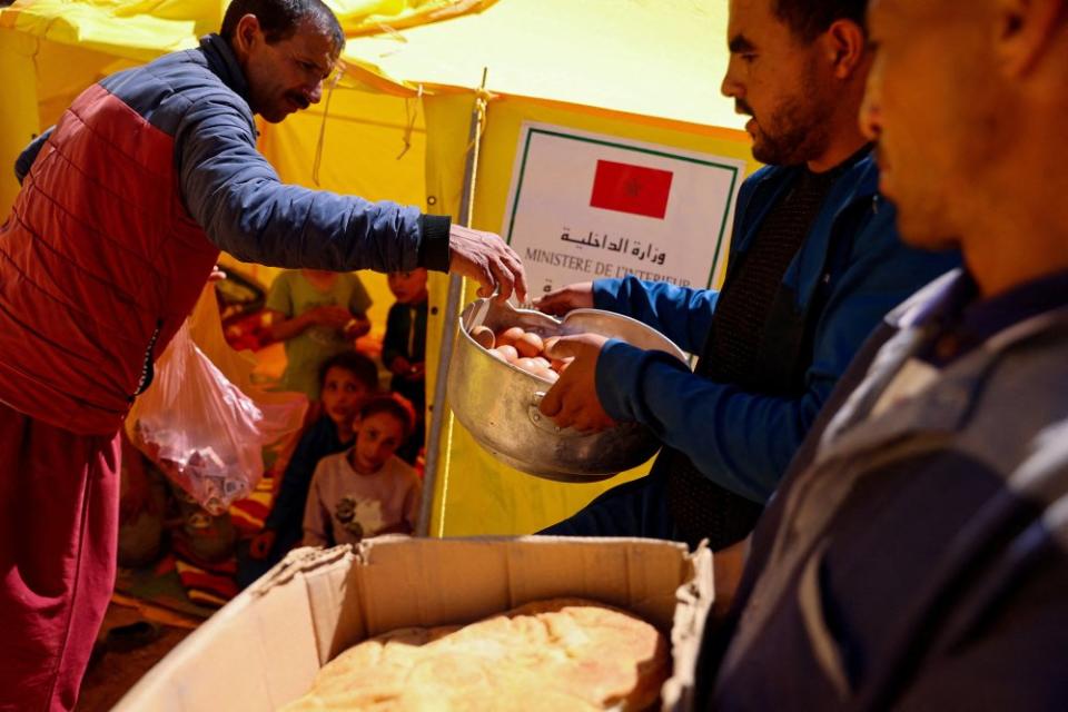 People receive food in the aftermath of the earthquake in Adassil on Sept. 11. <span class="copyright">Nacho Doce—Reuters</span>