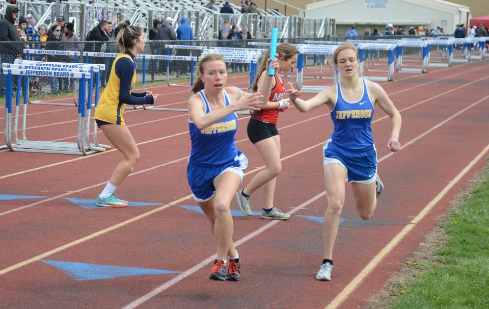 Jenna PIlachowski gets the baton from Jefferson teammate Kim Miller at the Jefferson Invitational Saturday. Jefferson won the event and the meet.