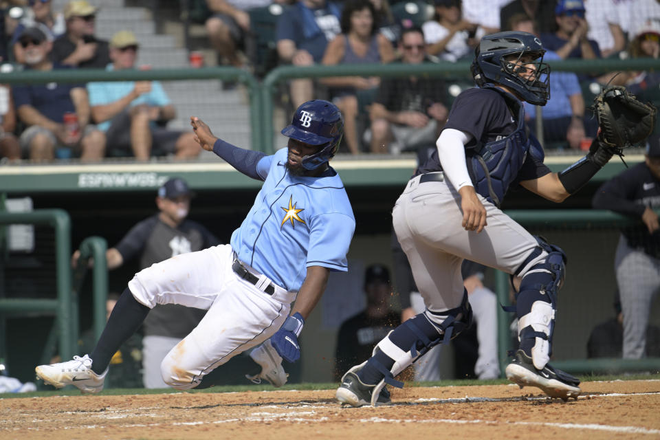 Tampa Bay Rays' Osleivis Basabe, left, scores a run on a two-RBI single by Tristan Peters as New York Yankees catcher Anthony Seigler waits for the throw during the seventh inning of a spring training baseball game, Tuesday, Feb. 28, 2023, in Kissimmee, Fla. (AP Photo/Phelan M. Ebenhack)