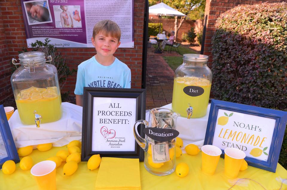 Noah Moore, 8, works to help customers at his lemonade stand in Spartanburg, S.C. Moore and his sisters raise funds for the American Heart Association.