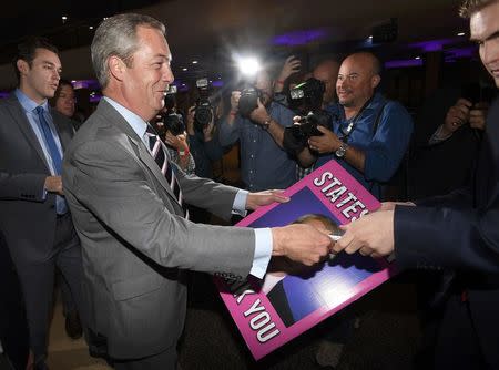 Nigel Farage, the outgoing leader of the United Kingdom Independence Party (UKIP), signs a placard as he arrives at the party's annual conference in Bournemouth, Britain, September 16, 2016. REUTERS/Toby Melville