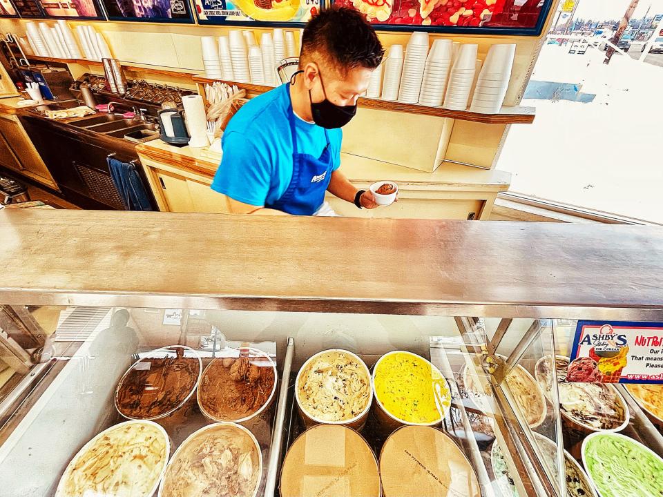 Lim’s Ice Cream co-owner Danny Lim scoops up a cup of amaretto chocolate for a customer during the grand-reopening for the restaurant on Friday, Jan. 8, 2021.