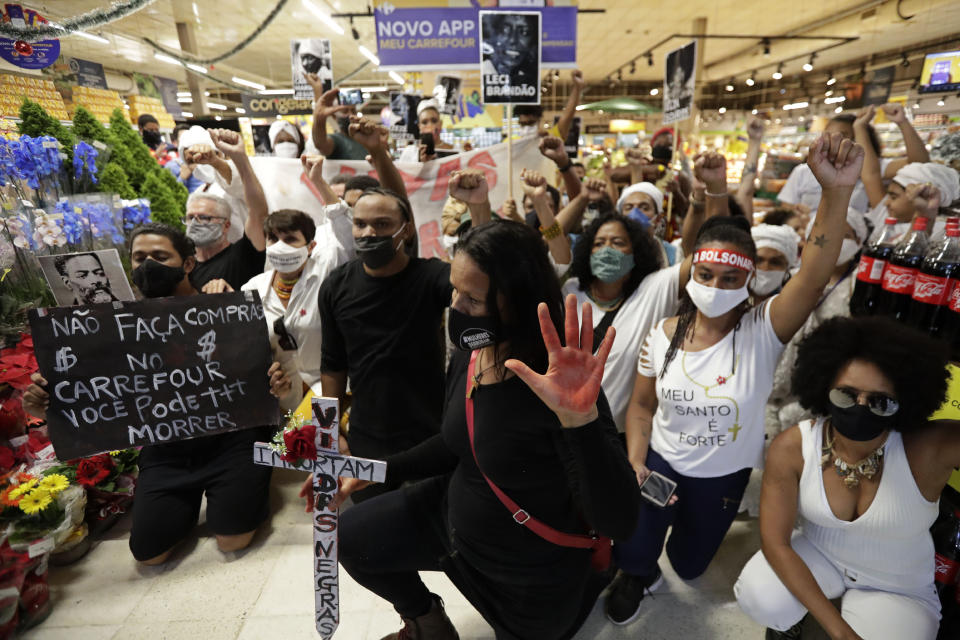 Activists including members of Black Lives Matter demonstrate against the murder of Black man João Alberto Silveira Freitas at a different Carrefour supermarket the night before, on Brazil's National Black Consciousness Day in Brasilia, Brazil, Friday, Nov. 20, 2020. Freitas died after being beaten by supermarket security guards in the southern Brazilian city of Porto Alegre, sparking outrage as videos of the incident circulated on social media. (AP Photo/Eraldo Peres)