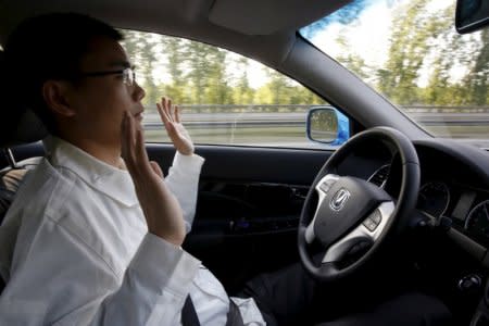 FILE PHOTO: Li Zengwen, a development engineer at Changan Automobile, lifts his hands off the steering wheel as the car is on self-driving mode during a test drive on a highway in Beijing, China, April 16, 2016. REUTERS/Kim Kyung-Hoon/File Photo