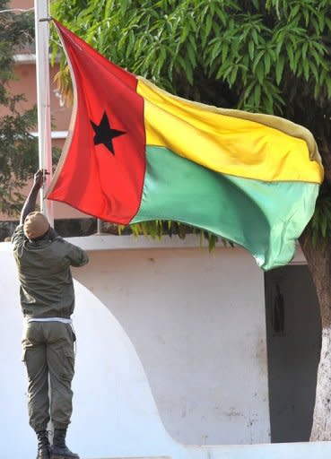 A Guinea-Bissau soldier lowers the flag at the Fortaleza d'Amura Military camp in Bissau, April 17. Guinea-Bissau's coup leaders released the country's ousted prime minister and interim president after more than two weeks of captivity, allowing the former leaders to travel to Ivory Coast