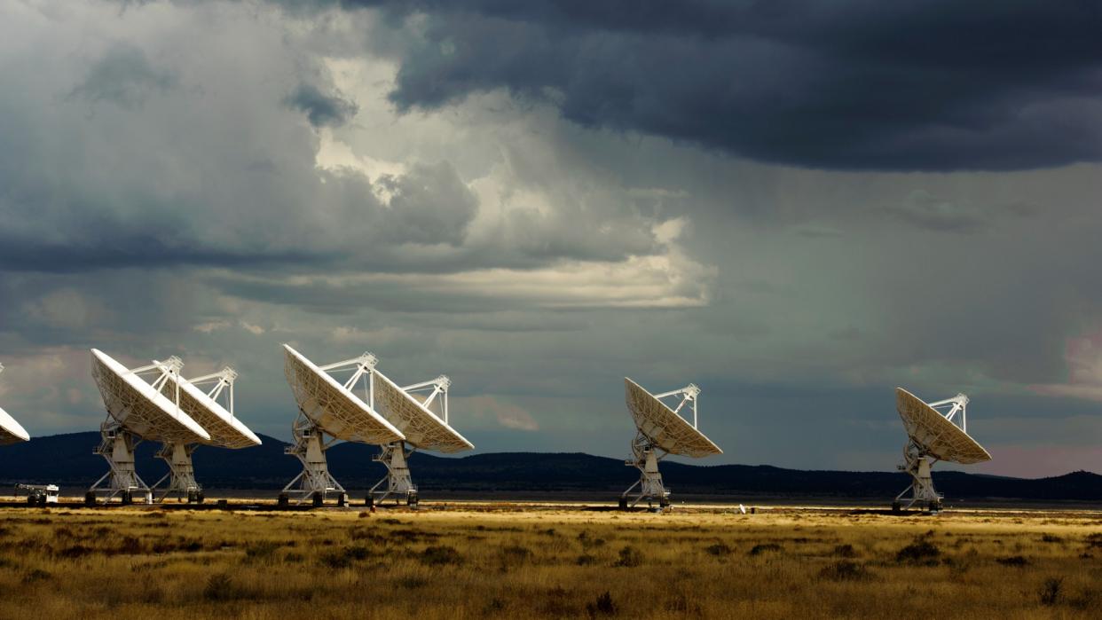  A set of large white antenna dishes in the desert. 