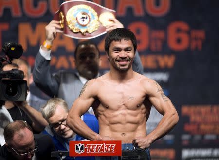 WBO welterweight champion Manny Pacquiao of the Philippines poses on the scale during an official weigh-in at the MGM Grand Garden Arena in Las Vegas, Nevada May 1, 2015. REUTERS/Steve Marcus