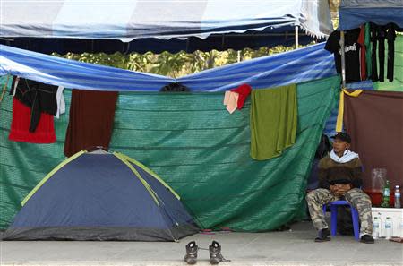 An anti-government protester takes a rest beside his tent during a rally near the Government Complex in Bangkok January 24, 2014. REUTERS/Chaiwat Subprasom