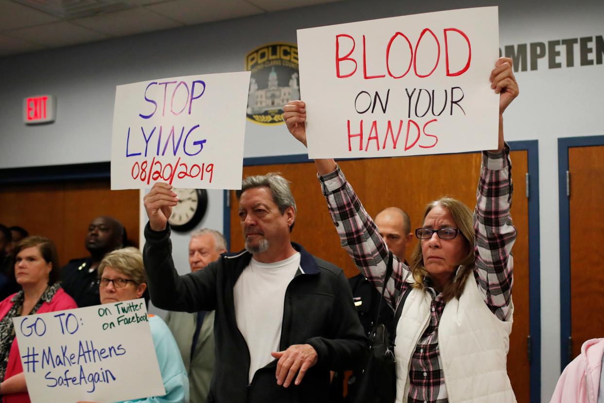 Protesters hold up signs and heckle while Athens-Clarke County Mayor Kelly Girtz spokes to the media along side Police Chief Jerry Saulters on community safety initiatives and ACCÕs status related to immigration on Wednesday, Feb. 28, 2024. Girtz also spoke about improvements that will be make to cameras around the community to help combat violent crime.