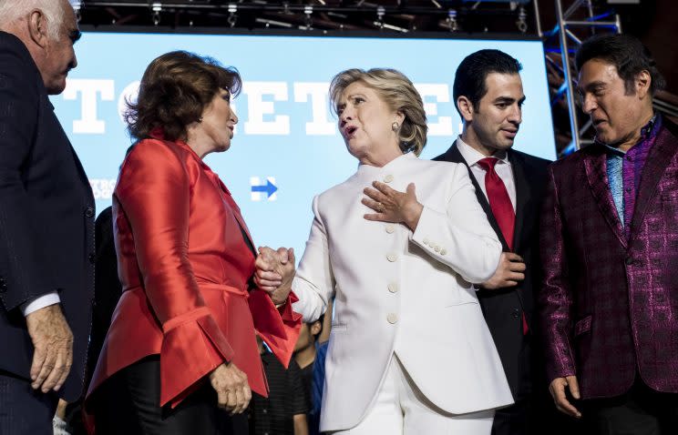 Hillary Clinton and singer Vicente Fernandez, left, stand on stage together at debate watch party in North Las Vegas, Nev. (Photo: Andrew Harnik/AP)