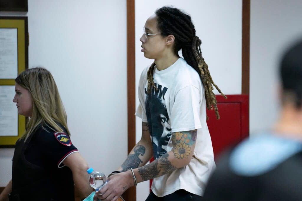 WNBA star and two-time Olympic gold medalist Brittney Griner is escorted to a courtroom for a hearing, in Khimki just outside Moscow, Russia, Friday, July 1, 2022. (AP Photo/Alexander Zemlianichenko)