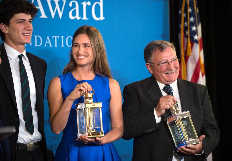 Accepting the 2014 John F. Kennedy Profile in Courage Award on behalf of her grandfather former President George H.W. Bush, Lauren Bush Lauren, center, and fellow Award recipient Paul W. Bridges, the former mayor of Uvalda, Ga, right, hold the awards as they stand with Jack Schlossberg, left, grandson of President John F. Kennedy, during a ceremony at the John F. Kennedy Library and Museum, Sunday, May 4, 2014, in Boston. (AP Photo/Gretchen Ertl)