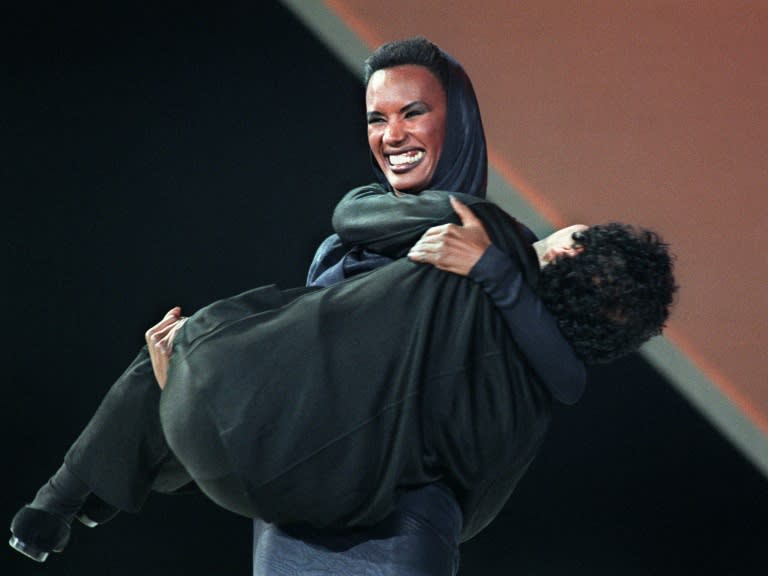 Pop star Grace Jones wears Azzedine Alaia's famous hooded dress as she holds the designer in 1987