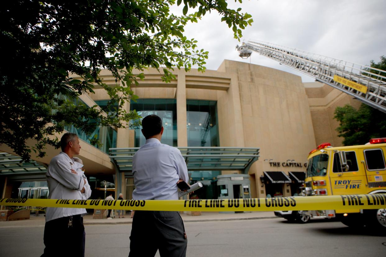 Workers from The Capital Grille wait outside the restaurant as the firefighters from the Troy Fire Department gather outside the Somerset Collection in Troy to put down the unknown fire on June 13, 2022.