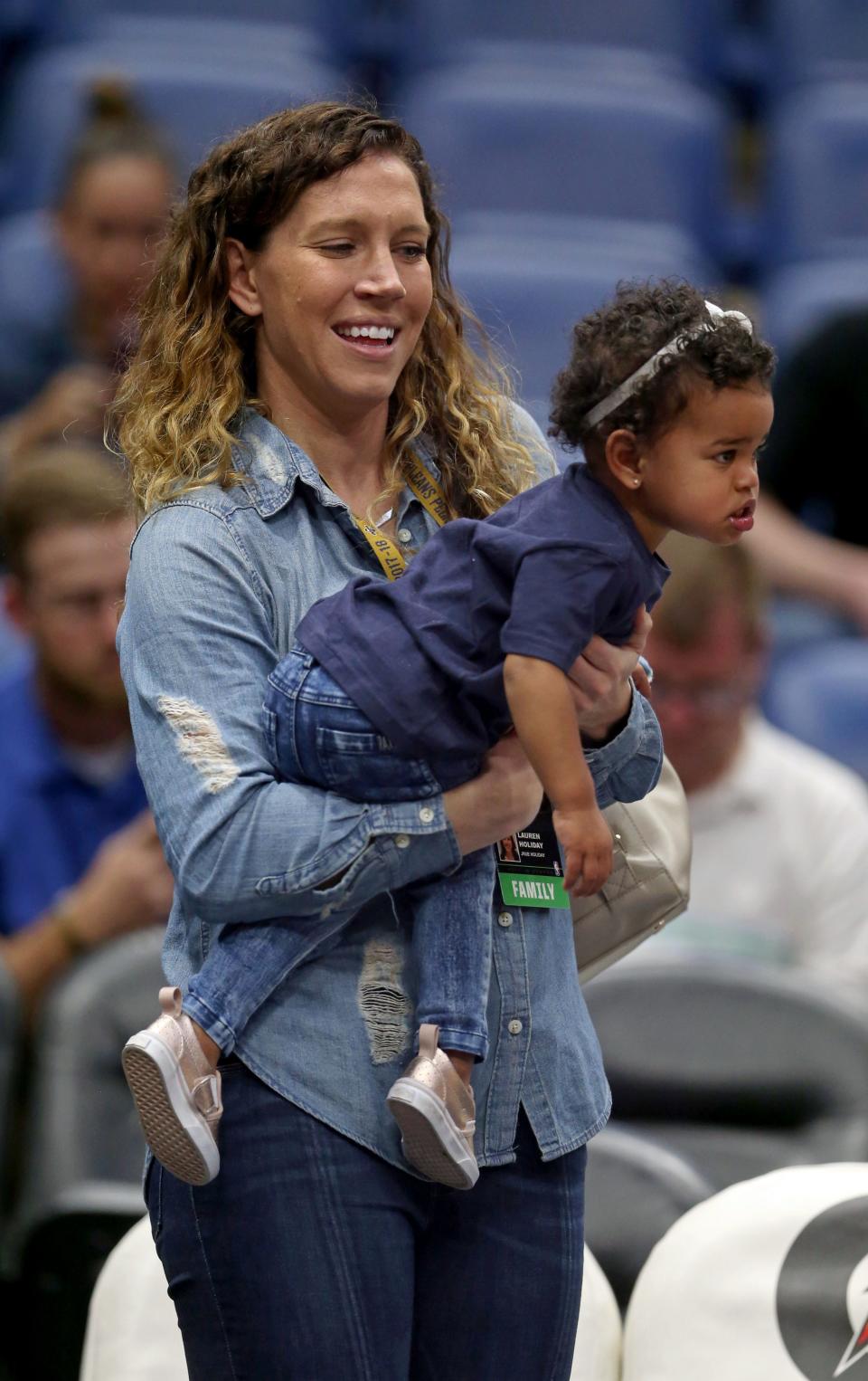 Lauren Holiday holds her daughter, J.T., before the game in 2018. She had a brain tumor removed four weeks after she gave birth to J.T. in 2016.