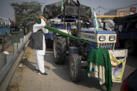 Jagir Singh, 71, ties his turban before joining fellow farmers for a protest against new farm laws, at the Delhi-Haryana state border, India, Tuesday, Dec. 1, 2020. The farmers have laid a siege of sorts on the highway, sleeping inside the trailers or under the trucks at night. During the day, they sit huddled in groups at the backs of the vehicles, surrounded by mounds of rice, lentils and vegetables. They say they are not going to leave the place until their demands are met. (AP Photo/Altaf Qadri)